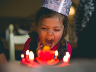 Child blowing out birthday candles