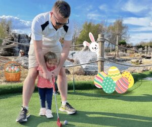 father and daughter playing golf