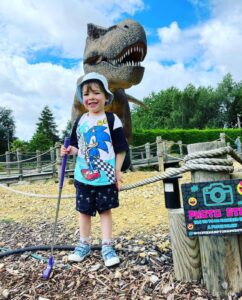 Child posing with dinosaur at Wolverhampton adventure golf