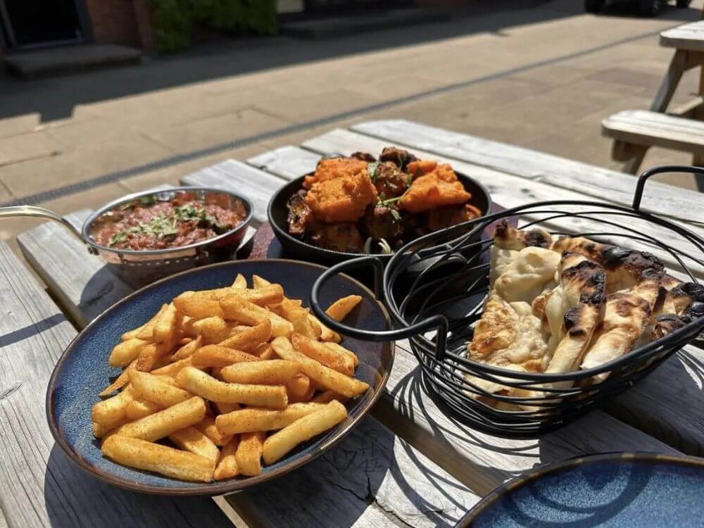 Chips, curry sauce, battered chicken and naan bread served outdoors at the Bunker café, Wolverhampton Adventure Golf