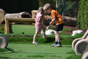 Two children playing adventure golf at Wolverhampton Adventure Golf course in Perton